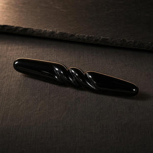Three-quarter view of The Obsidian Bar, the spiral catching the light